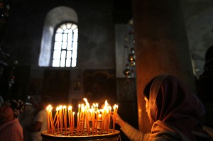 A Christian worshipper lights a candle at the Church of the Nativity, revered as the site of Jesus' birth, in the West Bank town of Bethlehem